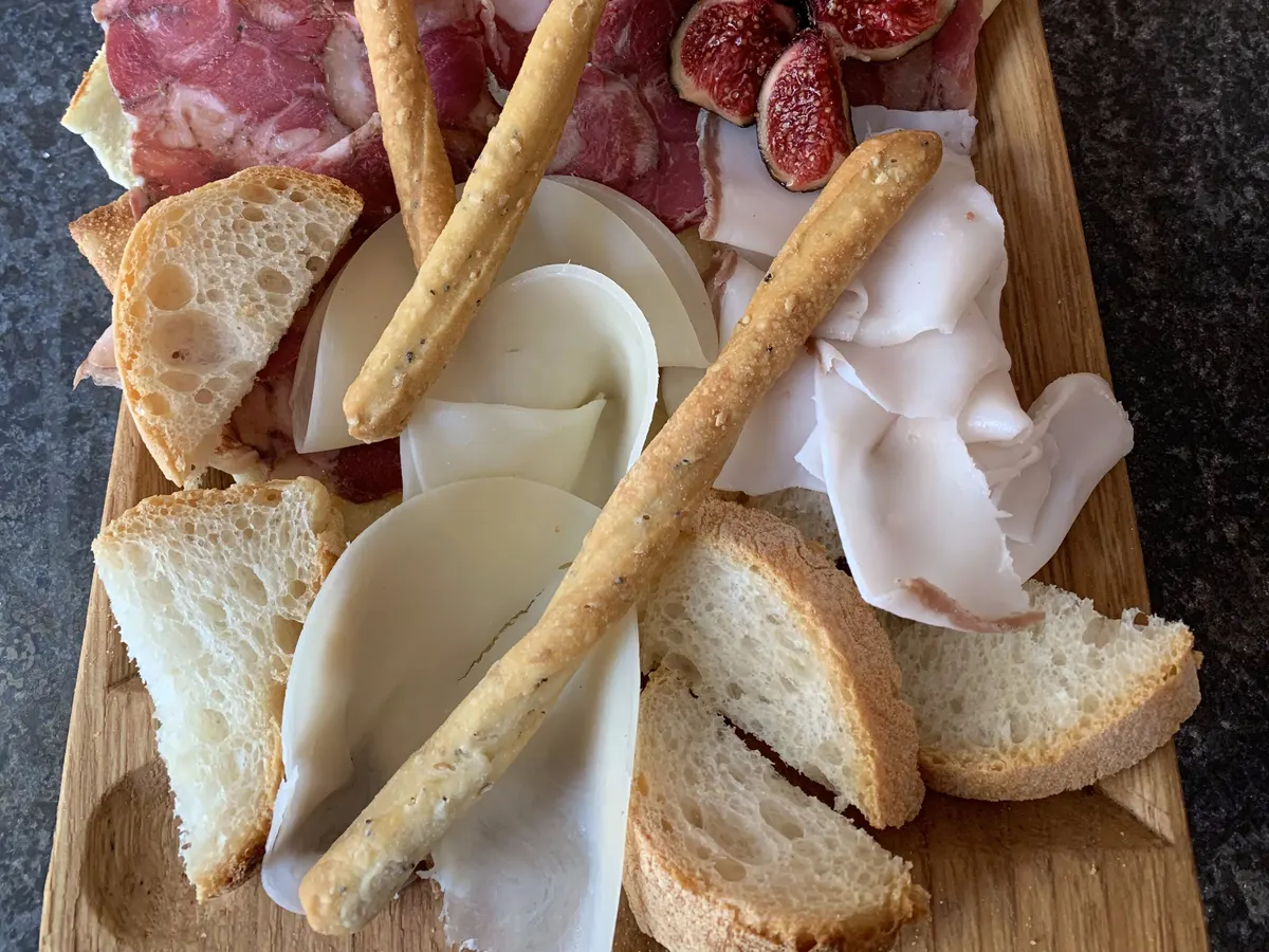 A board of cured meats, cheese and figs
