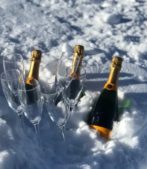 Champagne buried in the snow for a private snow dining experience
