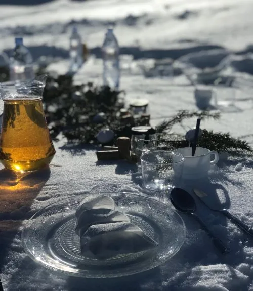 Wine glasses lined up on a table made of snow for a private dining experience