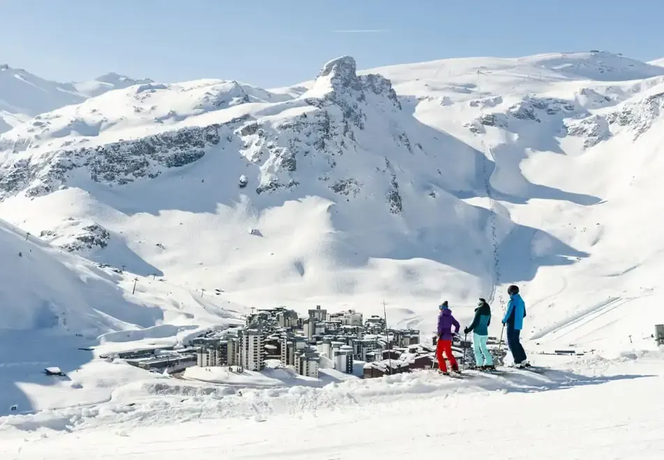 A group of skiers looking over Tignes covered in snow